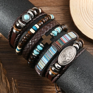 Detail eines mehrlagigen Boho-Armbands mit Türkisperlen, Leder und Kreuzanhänger