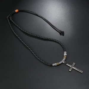 Detail of hand-woven cord necklace with black cross pendant and Spanish prayer engraving