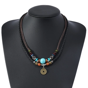 Détail d'un collier vintage à double couche avec perles et pendentif pièce en bronze