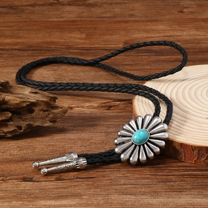 Détail d'une cravate bolo vintage avec pierre turquoise sertie dans un fermoir tournesol
