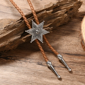 Gros plan sur le pendentif étoile du bolo tie en cuir tressé marron et embouts argentés