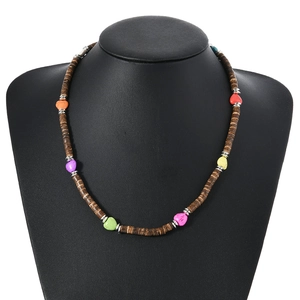 Collier bohème avec perles de cœur colorées et disques de noix de coco sur présentoir noir