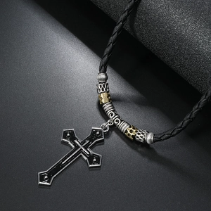 Macro shot of vintage silver cross pendant with black glaze and intricate metal spacer beads