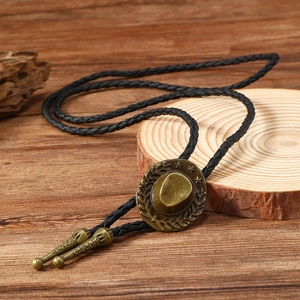 Detail of vintage bronze cowboy hat bolo tie with star texture on wood background
