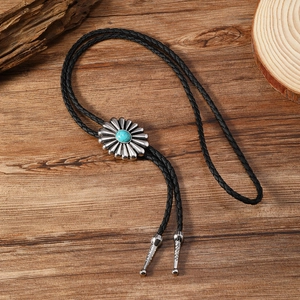 Détail de la cravate bolo western avec centre en turquoise et fermoir fleur argent
