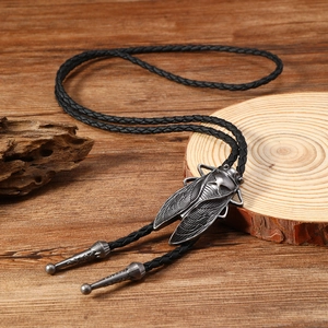 Close-up of vintage cicada bolo tie with silver alloy pendant and black braided rope