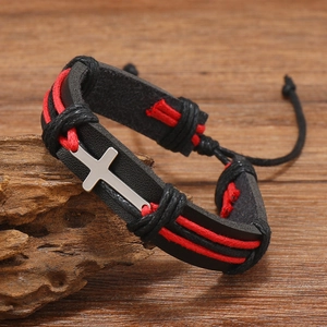 Detail of punk leather bracelet with red woven cords and polished silver cross pendant