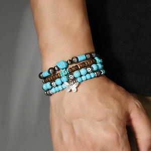 Gros plan sur un ensemble de bracelets bohèmes avec perles turquoise et pendentif papillon