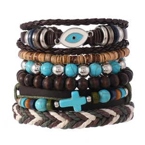 Détail d'un bracelet bohème multicouche avec cuir, perles en bois et breloque œil bleu