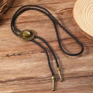 Detailed macro view of vintage bronze cowboy hat slide on black leather bolo tie cord
