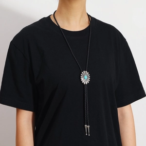 Gros plan sur la cravate Bolo vintage avec pendentif marguerite et pierre turquoise