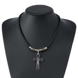 Close-up of vintage alloy cross pendant on a braided black leather cord necklace