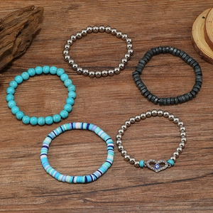 Detail of bohemian five-piece bracelet set with turquoise beads and heart evil eye pendant