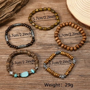Detail of bohemian turquoise beaded bracelets set on rustic wood background with specs