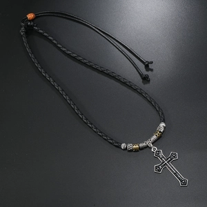 Detail of cross pendant necklace with vintage beads and black braided leather cord
