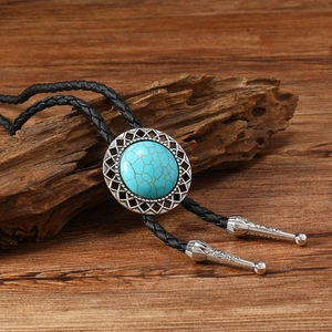 Détail macro de cravate bolo turquoise avec embouts en argent gravé sur bois