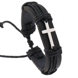 Detail of black braided leather bracelet featuring a silver metal cross and adjustable cord