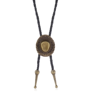 Detail of vintage bronze cowboy hat bolo tie buckle with black braided cord and engraved tips