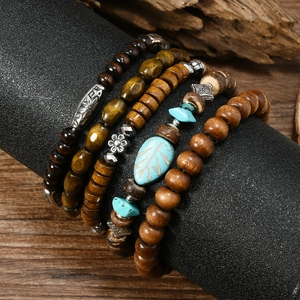 Detail of vintage bohemian multi-layer wooden bead bracelet with leaf turquoise charm