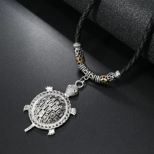 Detailed close-up of retro silver turtle pendant with honeycomb texture on black cord