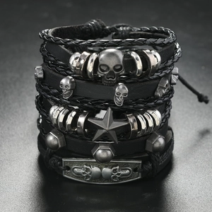 Detail of punk leather bracelet set featuring silver skulls and a pentagram star charm