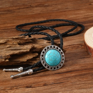 Détail d'une cravate bolo vintage en turquoise avec cadre en argent sur bois rustique