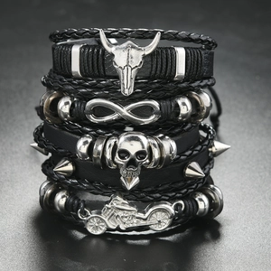 Detail of men's punk layered leather bracelet with bull skull and motorcycle charms