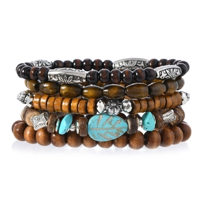 Detail of bohemian turquoise leaf charm on multilayer wood bead bracelet stack