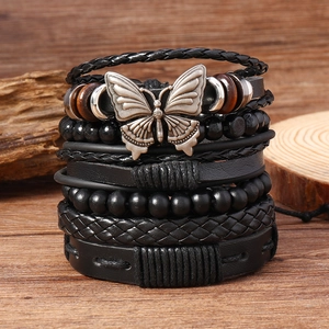 Détail macro du bracelet multicouche bohème avec breloque papillon sur bois