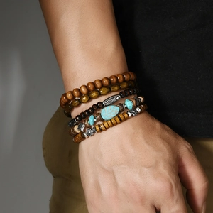 Detail of bohemian layered beaded bracelet featuring turquoise stones and ethnic charms