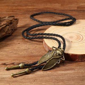 Close-up of bronze cicada pendant on a vintage bolo tie with braided leather cords