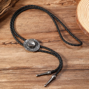 Detail of vintage silver western cowboy hat bolo tie with black braided leather cord