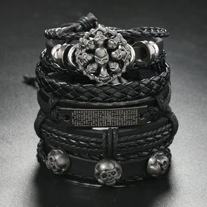Detail view of multi-layer leather bracelet set with skull charms and cross metal plate