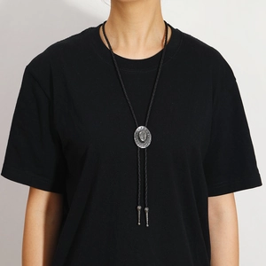 Detail of western bolo tie with silver cowboy hat slider and braided black cord