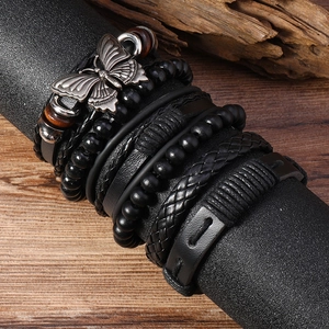 Gros plan détaillé de bracelets en cuir multicouches avec breloque papillon en argent