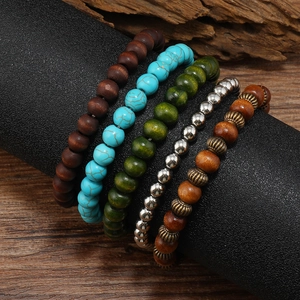Detailed view of bohemian turquoise and wooden beaded bracelets set with vintage metal spacers
