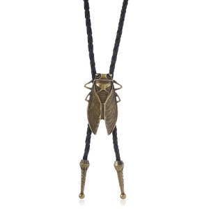 Detail of vintage bronze cicada bolo tie with black braided cord and metallic tips