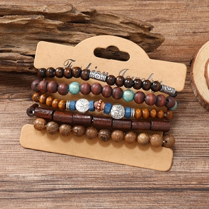 Detail of bohemian five-piece wooden bead bracelet set with silver tree of life charm