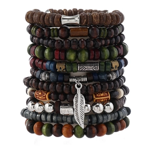 Detail of bohemian wooden bead bracelet set with a silver feather pendant and mixed beads