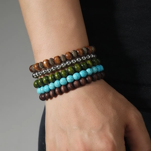 Detailed close-up of multilayered turquoise and wood bead bracelets for men and women