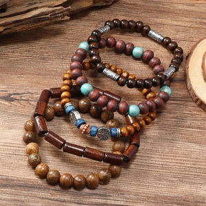 Detail view of multilayer turquoise and wood bead bracelet set with tree of life charm