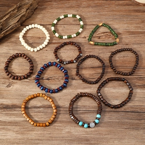 Close-up of Bohemian wood bead bracelets with turquoise and cat eye stones on wood