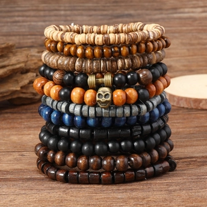 22-piece vintage stacked beaded bracelet set with skull and dumbbell charms on wood