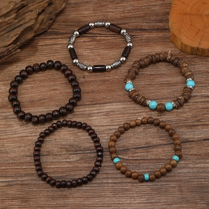 Set of five vintage turquoise and wood bead bracelets for men on a rustic wooden desk