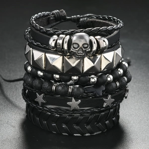 Detail of punk leather bracelet set with silver skull, metal studs, and star charms