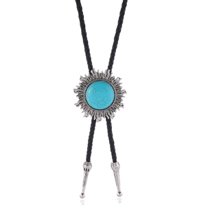 Détail de la cravate bolo vintage avec pendentif turquoise et cordon noir tressé