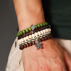 Détail de bracelets bohèmes en perles turquoise et bois avec des breloques feuilles