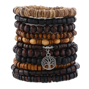 Macro shot of multi-layer wood beads and silver tree of life pendant on a vintage bracelet