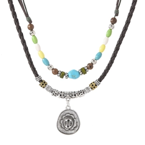 Detail of layered bohemian necklace with leather cord, antique pendant and colorful beads
