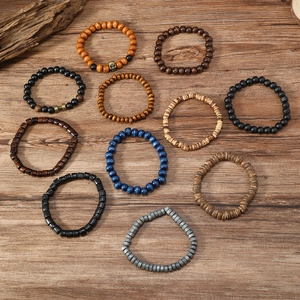 Macro shot of assorted multi-layer wooden bead bracelets with skull and dumbbell charms